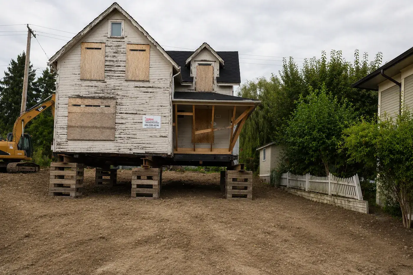 Heritage home on cribbing during relocation at 2085 Fraserview Dr